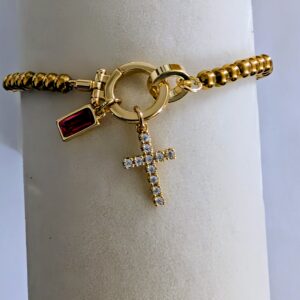 Gold bracelet featuring gemstone and cross
