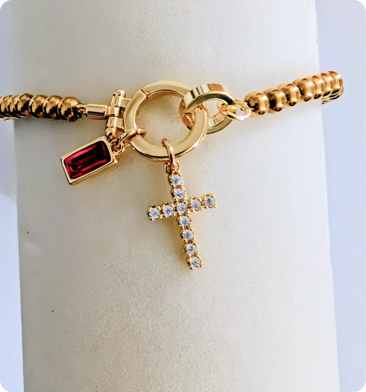 Elegant bracelet featuring cross and red charm